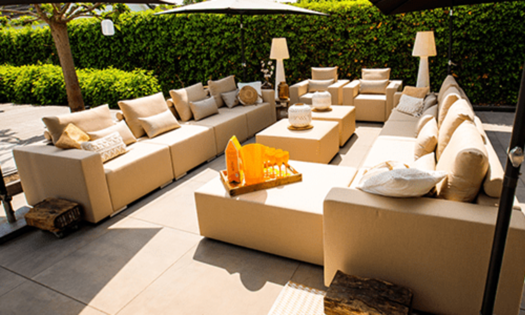 Oranje loungeset voor een heg in een tuin